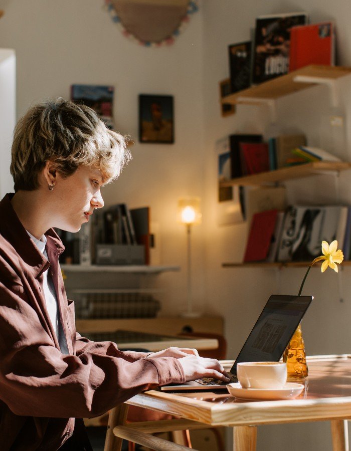 Sell Digital Products A woman with short hair typing on a laptop